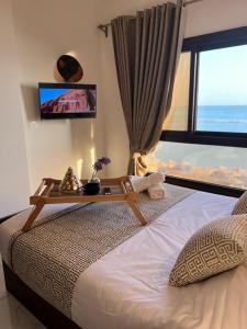 My Sky Sea View 1 Bedroom Apartment في الغردقة: غرفة نوم مع سرير مع طاولة عليه