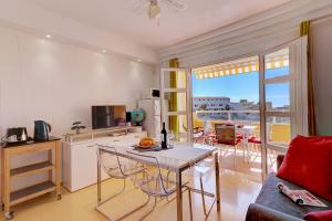 a living room with a table and a kitchen with a view at Orlando - Sea View Apartment in Costa Adeje in Adeje