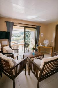 a living room with chairs and a couch and a table at Vue imprenable sur le lagon de Bora Bora in Bora Bora