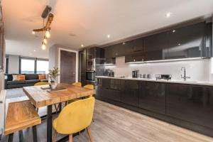 eine Küche und ein Wohnzimmer mit einem Holztisch in der Unterkunft Host & Stay - The Baltic Penthouse 1 in Liverpool