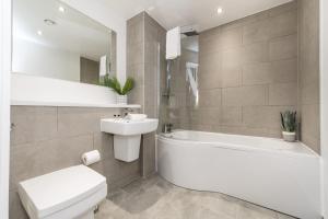 a bathroom with a white toilet and a tub and a sink at Host & Stay - The Baltic Penthouse 1 in Liverpool