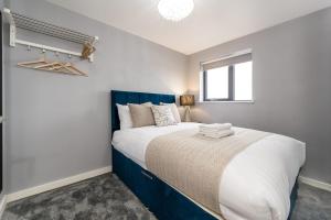 Schlafzimmer mit einem großen Bett mit blauem Kopfteil in der Unterkunft Host & Stay - The Baltic Penthouse 1 in Liverpool
