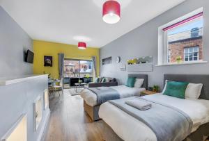 a bedroom with two beds and a living room at Host & Stay - Campbell Square Roof Terrace Apartment in Liverpool