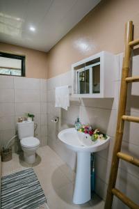 a bathroom with a white sink and a toilet at Vue imprenable sur le lagon de Bora Bora in Bora Bora