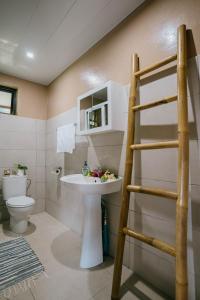 La salle de bains est pourvue d'un lavabo, de toilettes et d'une échelle. dans l'établissement Vue imprenable sur le lagon de Bora Bora, à Bora Bora
