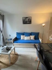 eine blaue Couch im Wohnzimmer in der Unterkunft Résidence Debussy - maeva Home - Appartement 2 Pièces 4 Personnes - Select 39 in Carnoux
