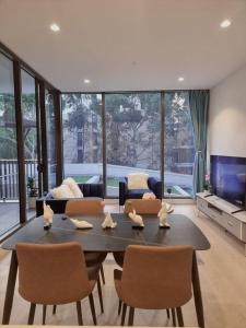 uma sala de estar com uma mesa e cadeiras e um sofá em Sapphire Royale Suite in Macquarie Park em Sidney