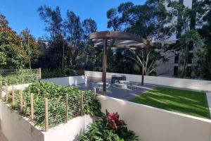 a garden with a fence and an umbrella at Sapphire Royale Suite in Macquarie Park in Sydney