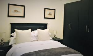 a bedroom with a bed with black cabinets and white pillows at Green Gables in Johannesburg