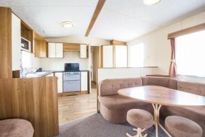 a living room with a couch and a table at Great 8 Berth Caravan For Hire At Seawick Holiday Park In Essex Ref 27227sw in Clacton-on-Sea