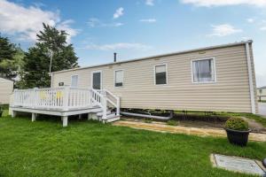 a mobile home with a porch and a deck at Great 8 Berth Caravan For Hire At Seawick Holiday Park In Essex Ref 27227sw in Clacton-on-Sea