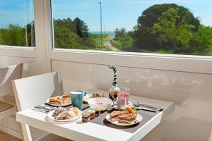 Hotel Residence Le Dune breakfast included في ليدو أدريانو: طاولة مع أطباق من الطعام ونافذة