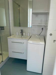a white bathroom with a sink and a mirror at Studio vue mer exceptionnelle proche métro et bus in Marseille