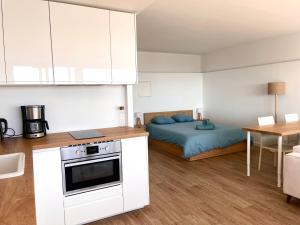 a small kitchen with a bed in a room at Studio vue mer exceptionnelle proche métro et bus in Marseille