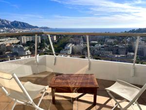 a table and chairs on a balcony with a view at Studio vue mer exceptionnelle proche métro et bus in Marseille