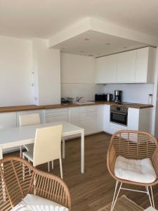 a kitchen with white cabinets and a table and chairs at Studio vue mer exceptionnelle proche métro et bus in Marseille