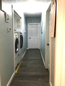 a hallway leading to a laundry room with a washer and dryer at Garden Clara in Yuba City