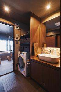 een badkamer met een wasmachine en een wastafel bij 奥琵琶湖　四季亭 in Kaizu