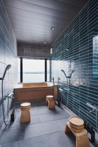 een badkamer met een bad en 2 toiletten bij 奥琵琶湖　四季亭 in Kaizu