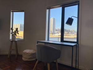 uma secretária com uma cadeira num quarto com uma janela em Superb City Views - Apartment, work or just relax! em Melbourne