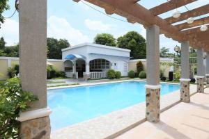 a swimming pool in a yard with a pergola at La Romana Countryside Haven in Anao