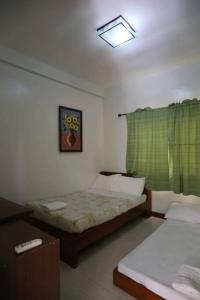 a bedroom with two beds and a green curtain at La Romana Countryside Haven in Anao