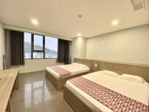a hotel room with two beds and two windows at 23D Thùy Vân sát biển - Lầu 20 khách sạn Sơn Thịnh 134 in Vung Tau