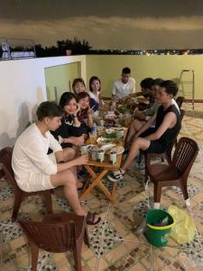 Ấp Sung Xuân的住宿－Homestay Hoài Tâm Phan Thiết，一群人坐在桌子旁