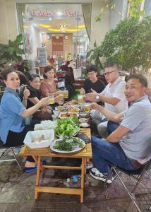 a group of people sitting around a table with food at Phuc Con Son Hotel in Con Dao
