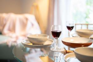 a table with two glasses of red wine and plates at The Coach House - Lyth Valley by LetMeStay in Kendal