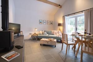 a living room with a blue couch and a fireplace at The Coach House - Lyth Valley by LetMeStay in Kendal