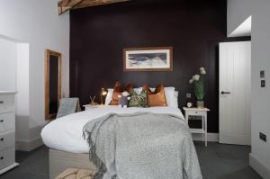 a bedroom with a large bed with a black wall at The Coach House - Lyth Valley by LetMeStay in Kendal