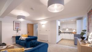 sala de estar con sofá azul y cocina en Bronte Apartment - Dales - Lakes - Kirkby Lonsdale en Carnforth