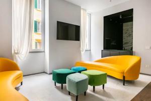 a living room with a yellow couch and green ottoman at ECOZYHOUSE in Florence