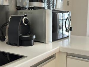 a kitchen counter with a coffee maker and a microwave at Emaar Fashion avenue-Formerly The Address Dubai Mall residence - Downtown by Suitestay Homes in Dubai