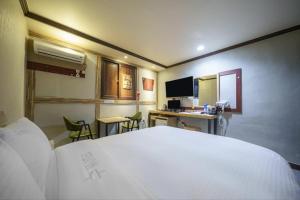 a bedroom with a bed and a desk with a computer at Subiztel in Pohang