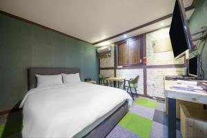 a bedroom with a bed and a desk with a television at Subiztel in Pohang +10 photos