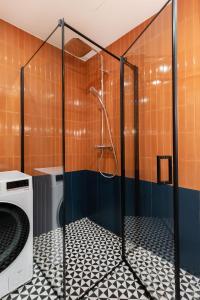 a shower in a bathroom with a washing machine at Cosy Home Paupys in Vilnius