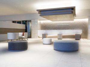 a lobby with tables and chairs in a building at Daiwa Roynet Hotel Nagoya Shinkansenguchi in Nagoya