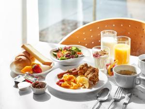 Daiwa Roynet Hotel Nagoya Shinkansenguchi في ناغويا: طاولة مع طبق من طعام ومشروبات الإفطار