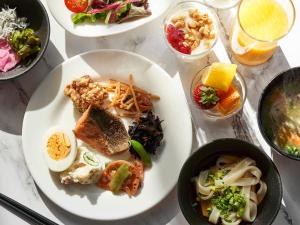 a table topped with plates of food and drinks at Daiwa Roynet Hotel Nagoya Shinkansenguchi in Nagoya