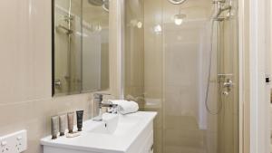 a white bathroom with a sink and a shower at Alpine Haven 5 in Mount Hotham
