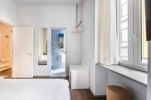 ein weißes Schlafzimmer mit einem Bett und einem Fenster in der Unterkunft ECOZYHOUSE in Florenz
