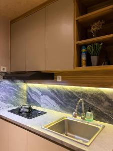 a kitchen with a sink and a counter top at R30 Apartemen Gateway Pasteur 2BR Daymentroom in Bandung +11 photos
