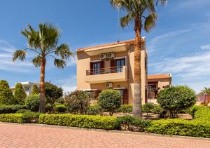 a house with palm trees in front of it at Gold Crest Home in Drapanias beach, Nopigia in Kissamos