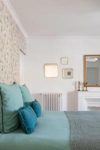 a bedroom with a bed with blue pillows at Maison Douce Arles in Arles