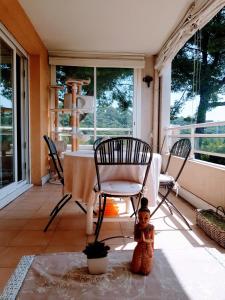 a porch with a table and chairs and a doll at Trois pièces proche de la mer in Cannes