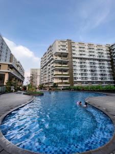 una piscina frente a algunos edificios de apartamentos en R30 Apartemen Gateway Pasteur 2BR Daymentroom en Bandung