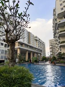 a swimming pool in the middle of two buildings at R30 Apartemen Gateway Pasteur 2BR Daymentroom in Bandung