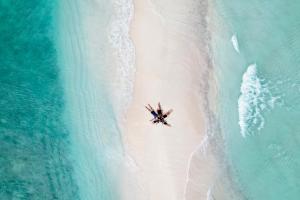 una vista dall'alto di una spiaggia con un gruppo di persone su di essa di Stingray Beach Inn a Maafushi